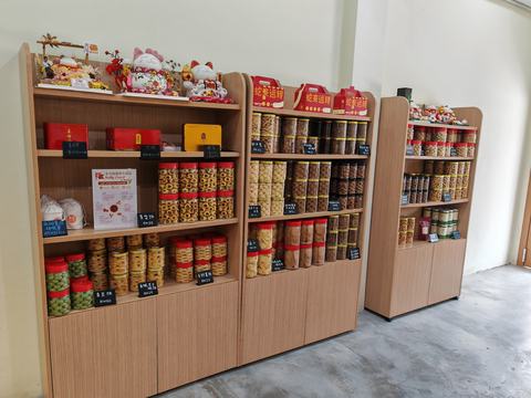 Wooden shelves of jars, tins and red gift boxes